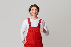 Handyman Services Concept. Portrait Of Smiling Young Workman In Uniform Showing Thumb Up, Panorama With Copy Space photo