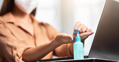 Close up of female hands using wash hand sanitizer gel pump dispenser, killing germs, bacteria and virus, panorama, copyspace photo