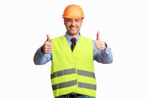 Happy Construction Worker Gesturing Thumbs Up Smiling To Camera Posing On White Background. Studio Shot photo