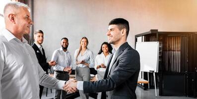 Career Promotion Concept. Happy Employee Shaking Hands With Boss During Corporate Business Meeting In Modern Office. photo