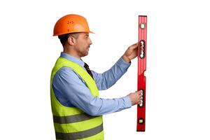 Professional Builder Holding Building Level Working Standing Over White Background In Studio, Wearing Orange Uniform And Helmet. Construction Tools Concept. Side View photo