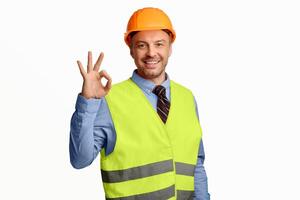 Building Is Okay. Construction Site Worker Gesturing Ok Posing Over White Studio Background, Smiling To Camera photo