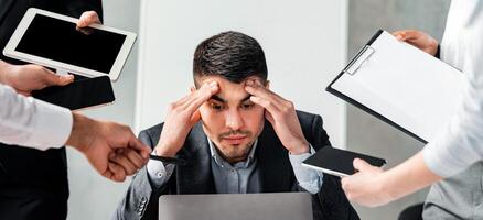 Multitasking Concept. Overworked Businessman Sitting At Laptop Overloaded With Work Multiple Tasks In Modern Office. photo