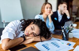 Boring Job. Depressed Business Lady Resting Head On Hands Uninterested In Work During Corporate Meeting In Office. photo