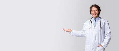 Clinic Ad. Friendly Young Doctor Pointing Aside At Copy Space With Hand, Inviting Visit Hospital For Check-Up photo