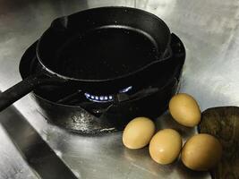 Cast iron pan wet from oil spray put on the stove,black color,prepare for cooking photo