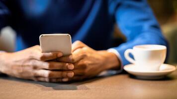 New Useful Application. Unrecognizable black man using cellphone sitting at table in cafe, having coffee photo