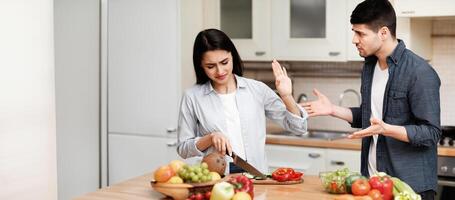 Leave Me Alone. Portrait of annoyed woman cooking and showing refusal stop gesture to sad man who asking what's wrong photo
