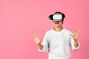 A woman is immersed in a virtual reality experience, wearing a headset and gesturing with her hands. Her expression conveys excitement and engagement as she explores a digital environment. photo