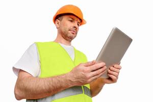 Serious Architect Using Digital Tablet Working On Construction Site Standing On White Studio Background. Building Project Concept. Low Angle photo
