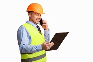 Construction Foreman Worker Talking On Phone Holding Folder Standing Over White Studio Background. Building Service Concept photo