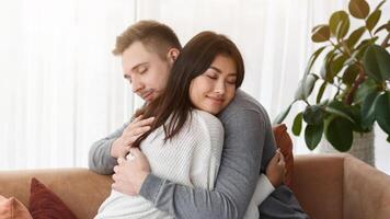 Reconciliation Concept. Multicultural Couple Hugging Supporting Each Other Or Reconciling After Quarrel At Home photo