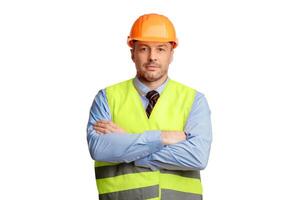 Construction Worker. Serious Builder Man Posing Crossing Hands Looking At Camera Standing Over White Background. Studio Shot photo