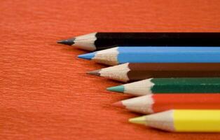 coloured pencils on red background photo