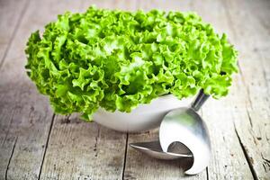 lettuce salad in a bowl and spoons photo