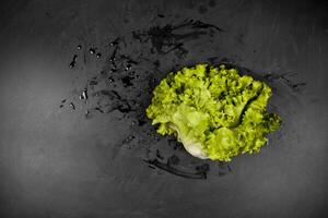 Fresh green wet lettuce salad on black background photo