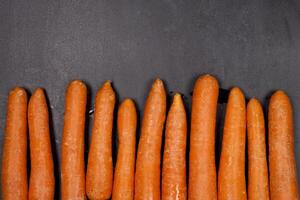 Fresh organic carrots on black background. photo