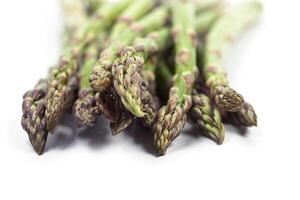 Bunch of fresh raw garden asparagus closeup on white background. Green spring vegetables. photo