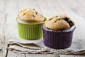 Homemade fresh muffins on ceramic bowls on linen napkin. photo