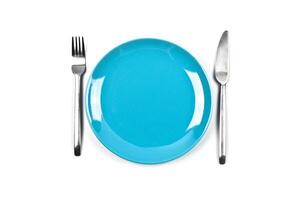 Set of empty blue plate, fork and knife on white background. photo