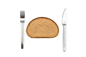 Fresh baked bread slice, fork and knife on white background. photo