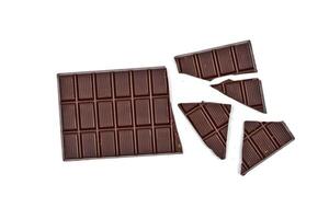 Broken dark chocolate bar isolated on white. photo