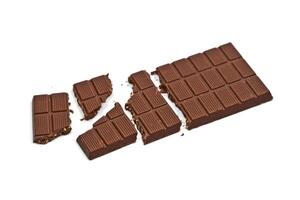 Broken milk chocolate bar with hazelnuts isolated on white. photo