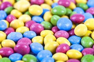 Pile of delicious ainbow colorful chocolate candies background. photo