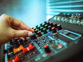 Close-up of sound engineer hands adjusting control sound mixer in recording, broadcasting studio,Sound mixer. Professional audio mixing console, buttons, faders and sliders. sound check. photo
