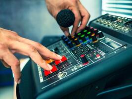 Close-up of sound engineer hands adjusting control sound mixer in recording, broadcasting studio,Sound mixer. Professional audio mixing console, buttons, faders and sliders. sound check. photo