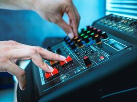 Sound engineer hands adjusting control sound mixer in recording, broadcasting studio,Sound mixer. Professional audio mixing console, buttons, faders and sliders. sound check. photo
