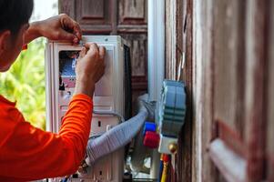 Air conditioning technicians install new compressor air Use a screwdriver to install the air conditioning system wiring and using monitor tool to check air conditioner system. photo