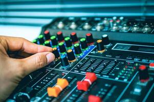 Close-up of sound engineer hands adjusting control sound mixer in recording, broadcasting studio,Sound mixer. Professional audio mixing console, buttons, faders and sliders. sound check. photo