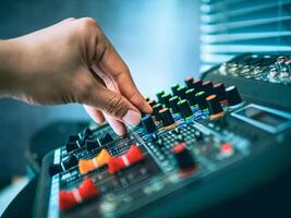 Close-up of sound engineer hands adjusting control sound mixer in recording, broadcasting studio,Sound mixer. Professional audio mixing console, buttons, faders and sliders. sound check. photo
