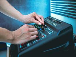 Sound engineer hands adjusting control sound mixer in recording, broadcasting studio,Sound mixer. Professional audio mixing console, buttons, faders and sliders. sound check. photo
