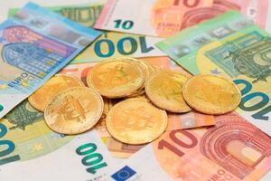A Heap of Bitcoin Coins on the Euro Banknotes. Money Saving, Cryptocurrency, Blockchain and Anonymous Payments Concept photo
