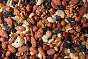 Mixed Nuts. Almonds, Walnuts, Cashews, Peanuts, Hazelnuts, Dried Prunes and Raisins. Different Nut Mix. Background from Various Nuts and Dried Fruits photo