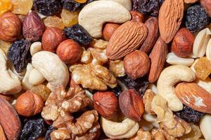 Mixed Nuts. Almonds, Walnuts, Cashews, Peanuts, Hazelnuts, Dried Prunes and Raisins. Different Nut Mix. Background from Various Nuts and Dried Fruits photo