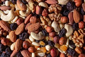 Mixed Nuts. Almonds, Walnuts, Cashews, Peanuts, Hazelnuts, Dried Prunes and Raisins. Different Nut Mix. Background from Various Nuts and Dried Fruits photo