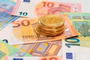 A Stack of Bitcoin Coins on the Euro Banknotes. Money Saving, Cryptocurrency, Blockchain and Anonymous Payments Concept photo