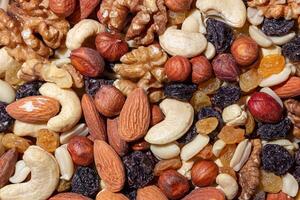 Mixed Nuts. Almonds, Walnuts, Cashews, Peanuts, Hazelnuts, Dried Prunes and Raisins. Different Nut Mix. Background from Various Nuts and Dried Fruits photo