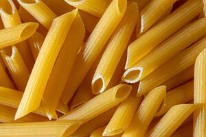 Uncooked Penne Rigate Pasta. A Culinary Canvas of Penne Macaroni, Creating a Lively and Textured Background for Gourmet Cooking. Dry Pasta. Raw Macaroni - Top View, Flat Lay photo
