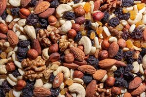 Mixed Nuts. Almonds, Walnuts, Cashews, Peanuts, Hazelnuts, Dried Prunes and Raisins. Different Nut Mix. Background from Various Nuts and Dried Fruits photo