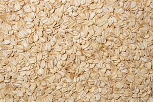 Uncooked Oat Flakes background - Top View, Flat Lay. Scattered Dry and Raw Oat Flakes. Healthy Breakfast and Diet Eating Ingredients photo