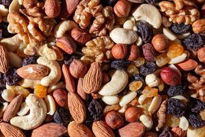 Mixed Nuts. Almonds, Walnuts, Cashews, Peanuts, Hazelnuts, Dried Prunes and Raisins. Different Nut Mix. Background from Various Nuts and Dried Fruits photo