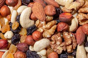 Mixed Nuts. Almonds, Walnuts, Cashews, Peanuts, Hazelnuts, Dried Prunes and Raisins. Different Nut Mix. Background from Various Nuts and Dried Fruits photo