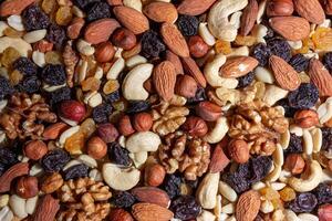 Mixed Nuts. Almonds, Walnuts, Cashews, Peanuts, Hazelnuts, Dried Prunes and Raisins. Different Nut Mix. Background from Various Nuts and Dried Fruits photo
