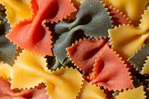 Uncooked Vibrant Colored Farfalle Pasta. A Culinary Canvas of Multicolored Bow-Tie Macaroni, Creating a Lively and Textured Background for Gourmet Cooking Enthusiasts. Colored Dry Pasta. Raw Macaroni photo