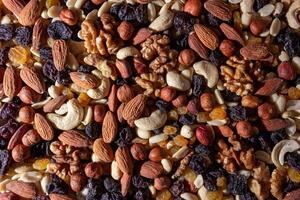 Mixed Nuts. Almonds, Walnuts, Cashews, Peanuts, Hazelnuts, Dried Prunes and Raisins. Different Nut Mix. Background from Various Nuts and Dried Fruits photo