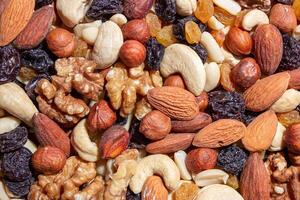 Mixed Nuts. Almonds, Walnuts, Cashews, Peanuts, Hazelnuts, Dried Prunes and Raisins. Different Nut Mix. Background from Various Nuts and Dried Fruits photo